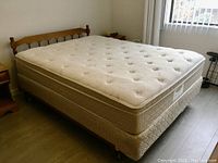 Full view of queen mattress and headboard with bed frame, showing overall condition