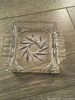 Top-down photo of the rectangular crystal ashtray showing starburst pattern etched deeply into the base with cut facets.