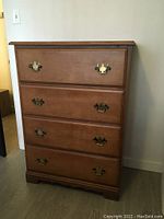 Front view showing the four drawers and brass-tone handles.