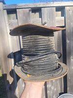 Wooden spool with copper wire coiled around it, showing wire thickness and condition