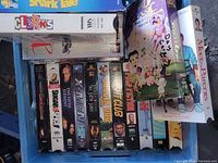 Photo showing VHS tapes including Clerks, The 5th Element, Fight Club, Donnie Brasco, Sugar & Spice, Se7en, and more stacked horizontally in a blue milk crate.