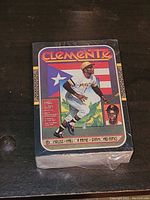 Front side showing sealed Roberto Clemente baseball card with team and branding visible.