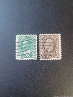 Front view of two rectangular Canadian postage stamps, green 1 cent with cancellation, and brown 2 cents without