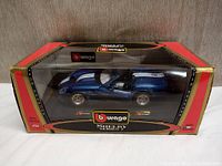 Blue Bburago Shelby model car in original branded box with clear display window.