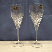 Pair of DaVinci crystal champagne flutes side by side with stickers visible near rim.