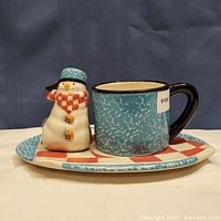 Photo showing the full set including the mug, plate, and the snowman figure attached to the plate.