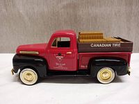 Side view of red and black Ford truck coin bank with Canadian Tire branding on the truck bed.