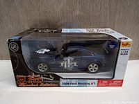 Photo of the Maisto 1:24 scale diecast 2006 Ford Mustang GT car in original box showing Toronto Maple Leafs special edition graphics.