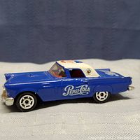 Side view of the blue and white Majorette Pepsi Cola 57 Ford Thunderbird diecast model showing detailed Pepsi logo decals and orange windows.
