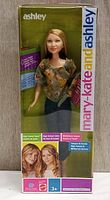 Ashley doll in original packaging showing full front view with floral blouse and jeans, box labeled with Mary-Kate & Ashley branding.