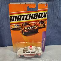 Matchbox Chevy Impala fire rescue die-cast car sealed in original blister card packaging with orange and purple branding and images of cars on the card.