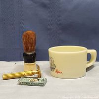 Full view of vintage shaving tools including brush, razor, blade pack, and Old Spice mug.