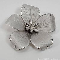 Full front view of the sterling silver flower brooch showing all five petals and central decorative buds