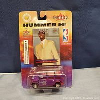 Front view of unopened Fleer Collectibles package containing Chris Bosh trading card and purple Toronto Raptors Hummer H2 model.