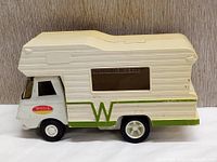 Side view of vintage Tonka camper truck toy showing white and green camper design with a window and the Tonka logo on the side.