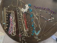Full view of assorted costume necklaces of various colors and styles laid out on table