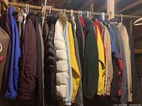 Photo showing variety of mens and womens coats and jackets in assorted colors and styles hanging on a rack