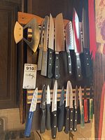 Photo showing full assortment of knives and mezzaluna mounted on two wooden magnetic racks.