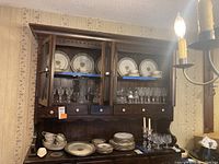 Overall view of wood cabinet shelves showing china and serving pieces