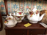Royal Albert Old Country Roses tea set on wooden surface, includes teapot, creamer, sugar bowl, and bowl