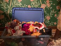 Large blue plastic bin filled to the brim with assorted TY Beanie Baby plush toys, showing various colors and figures packed densely.
