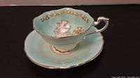 Side view of cup and saucer set on black background showing profile and gold trim