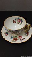 Tea cup and saucer set side view, floral decoration and butterfly handle visible