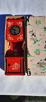 8 inch tall wooden grandfather clock in original box, showing full length and painted floral design