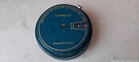 Top view close-up showing the blue thermalloy lid with coin counter window and company name.