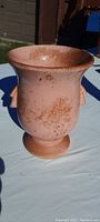 Front and side view of pink antique McCoy vase showing its unusual color and design, flared rim, pedestal base, and handles with attic dust and dirt.