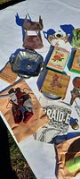 Photo showing various small collectibles including ceramic figurines, metal stand, plaque, key, vintage books, glassware