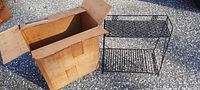 Metal rack floor unit next to original cardboard box, rack standing upright showing front and side sides.