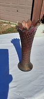 Full front view of the tall carnival glass vase showing the diamond patterned body and ruffled top edge with iridescent colors.