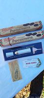 Two vintage Whitman's Peppermints candy boxes with small items including Four Roses keychain and beige packet.