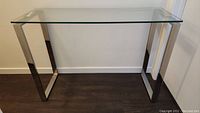 Front view of console table showing clear glass top and chrome metal frame