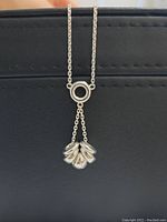 Close-up front view of the sterling silver loop pendant with five loops and a drop-shaped charm on chain.