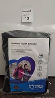 Packaged Universal Jacket Extender in original packaging with branding and product image showing two women demonstrating use during baby-carrying and pregnancy.