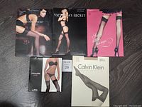 Group photo of the five boxed stockings and thigh-highs representing different styles and brands included in the lot.