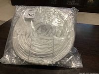 Photo of the flat-packed white paper lanterns showing Coors Light logo through clear plastic packaging.