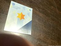 Front cover of the stamp booklet showing yellow star on geometric background and '10 Permanent Stamps Canada' text.