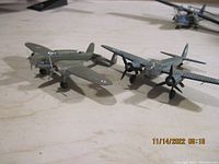 Two die cast model planes showing military camouflage and propeller details.
