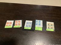 Various Canada MNH stamps with tagging from 1972-1979 laid out on a dark surface for display and identification.