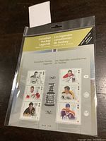 Full view of the sealed Canadian Hockey Legends Stamp Souvenir Sheet in a protective sleeve, showing six hockey player stamps and Stanley Cup trophy