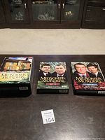 Three Midsomer Murders DVD box sets laid out on a wooden surface: The Early Cases, Series 16, and Series 13.