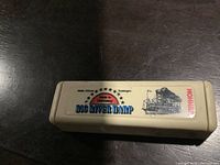 Top view of the beige plastic case with Hohner Big River Harp label showing a steamboat and text.