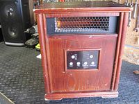 Front view of the electric heater showing mesh vent and control panel with buttons and indicator lights.