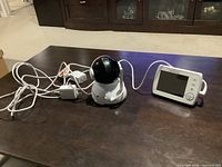 Full view of the Levana baby monitor set with camera, monitor screen, and power adapters on a table.