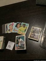 Wide view of grouped vintage baseball cards and bundled football cards on dark surface