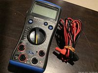Front view of Mastercraft digital multimeter showing rotary dial, display, and input ports with test leads bundled on the side.