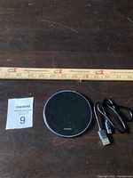 Photo showing the entire lot with the wireless charging pad, USB cable, and a ruler for size reference